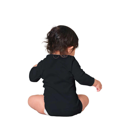 Baby wearing a Fox Classic Baby Long Sleeve Bodysuit in black, sitting on the floor, showcasing the back view.