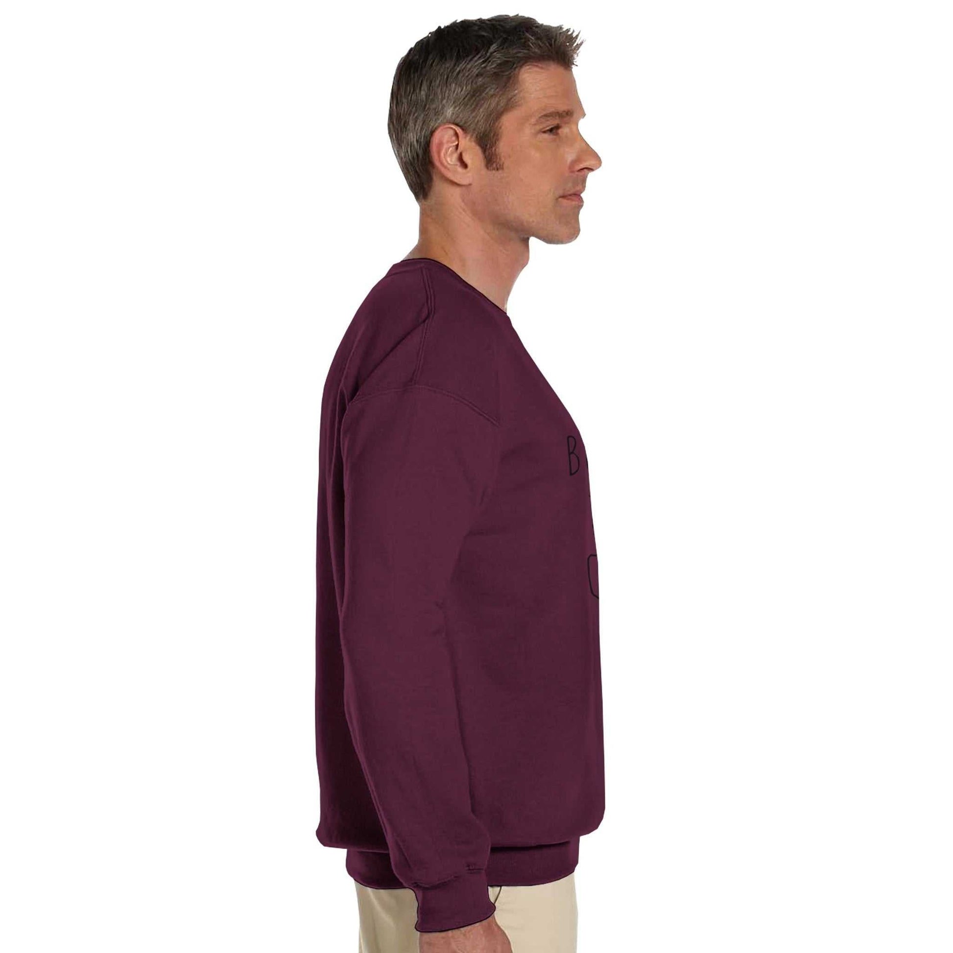 Side view of a man wearing a maroon "Boys do Cry" printed classic crewneck sweatshirt.