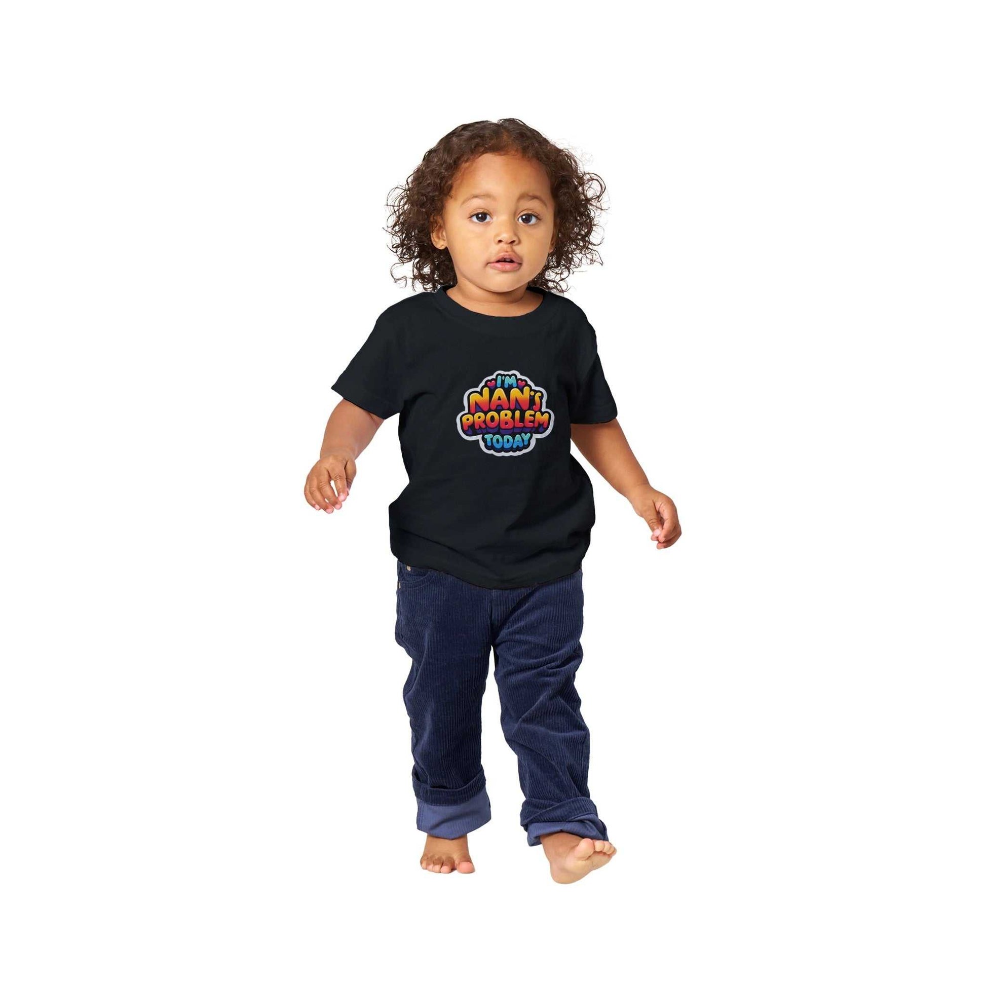 I'm Nan's Problem Today Baby Crewneck T-shirt; toddler wearing black crewneck with colorful text design.