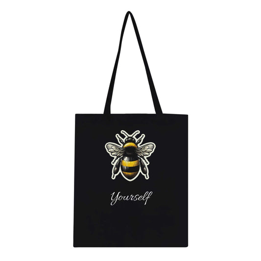 Black tote bag with a bee design and the text "Yourself," featuring long handles and reinforced stitching, eco-friendly and 100% cotton.